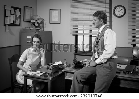 Businessman and young female secretary working in 1950s vintage office.