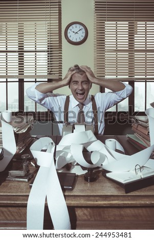 Desperate accountant shouting head in hands in vintage 1950s style office.