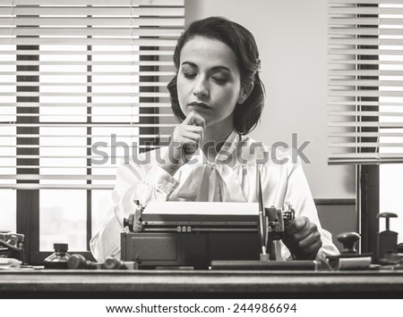 Pensive vintage woman with hand on chin, typing on typewriter and looking for inspiration