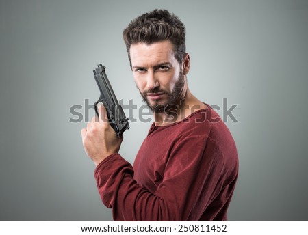 Confident aggressive man holding a gun, cool attitude