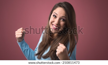Joyful smiling woman receiving good news with raised fists