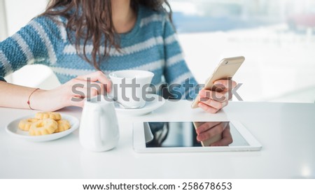 Woman at the bar sitting at the counter and using a mobile phone, hands detail