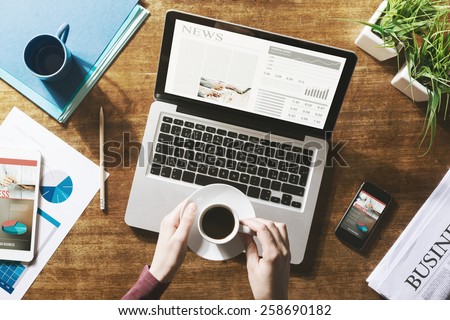 Financial business news online on a laptop with coffee and stationery