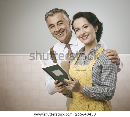 Vintage wife and husband reading a cookbook together at home