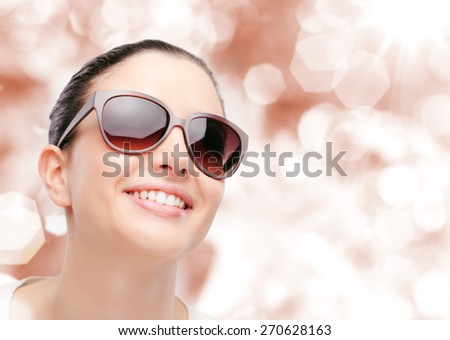 Young female fashion model wearing big sunglasses smiling