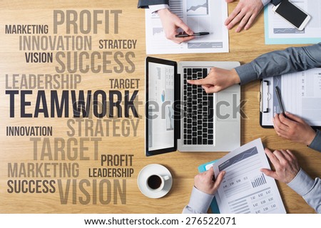 Business team hands at work with financial reports and a laptop, marketing and strategy concepts on the left, top view