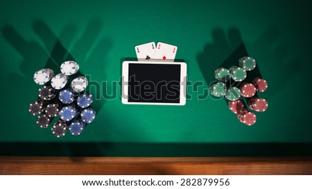 Online poker game app concept with digital tablet, cards and stacks of chips, top view