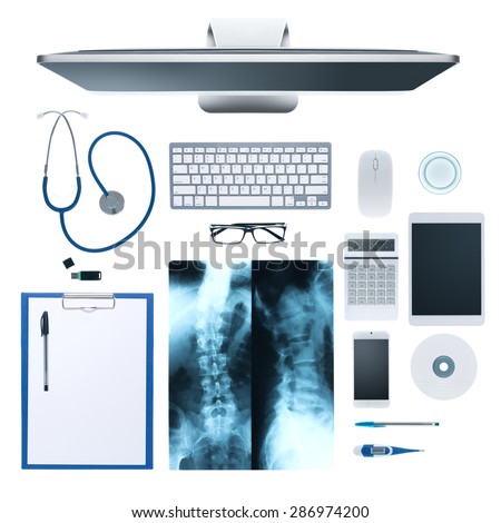 Doctor\'s desktop with medical equipment, computer and X-ray of human bones on white background, top view