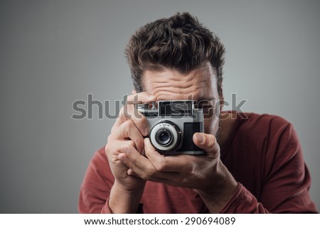 Young man taking pictures with an old vintage camera
