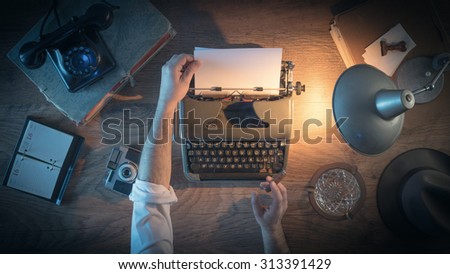 Vintage journalist\'s desk 1950s style, he is working and typing on his typewriter late at night, top view