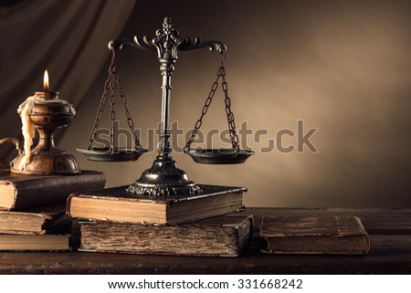 Old silver scale and hardcover books on a wooden table, justice and knowledge concept