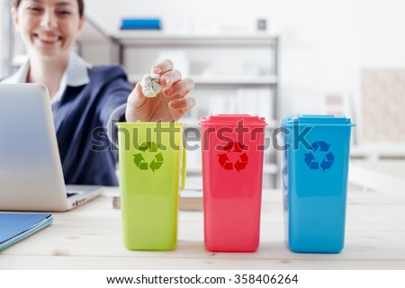 Waste separate collection and recycling in the workplace, office worker sorting garbage using different trash bins