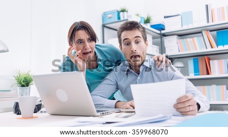 Stressed young couple checking bills, taxes and bank account balance, they are panicking, debt and cost of living concept