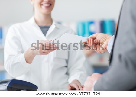Male customer at the pharmacy, he is giving a prescription to the pharmacist, healthcare concept