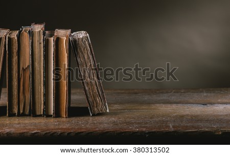 Ancient books on a ruined old table still life, literacy and wisdom concept