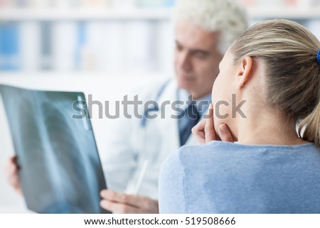 Woman having a consultation at doctor\'s office, the doctor is examining an x-ray, healthcare concept