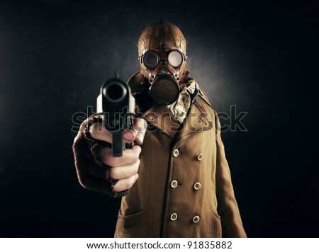 grunge portrait man in gas mask pointing a gun