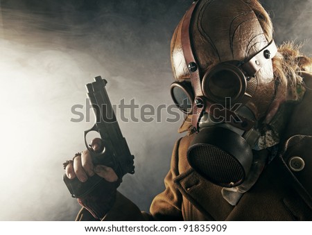 grunge portrait man with gun in gas mask
