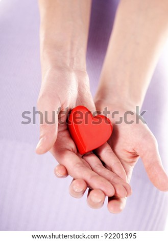 Holding a heart in cupped hands. Love and health care concept