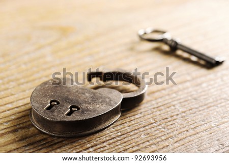 Antique Padlock with key on wooden table