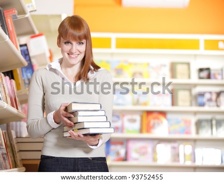 A portrait of a college student holding books in the library