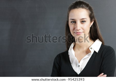 Portrait of a young woman, college student or teacher in front of a blackboard