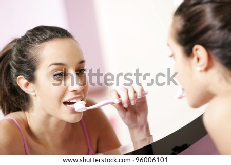 young woman in bathroom cleaning her teeth