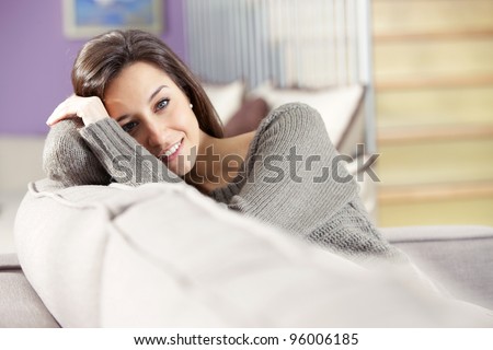 Portrait of a beautiful young woman lying on couch