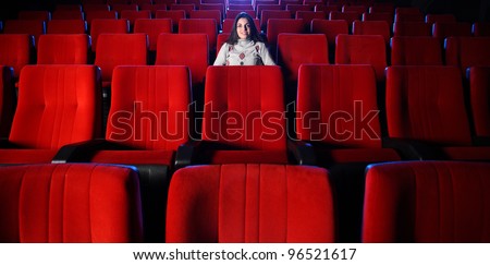 watching a movie at the cinema: portrait of a pretty girl in a movie theater