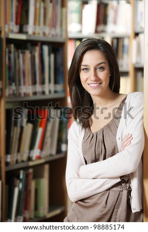Beautiful young woman standing in library