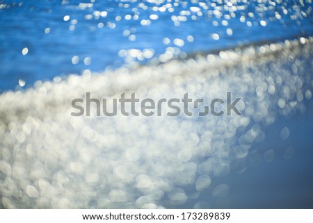 Sparkling sunlight in ocean waves background.
