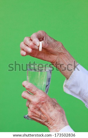 Senior woman ready to dissolve her pill in water and take it.