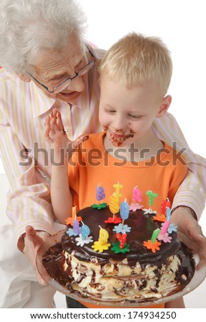 Happy senior woman sharing her birthday cake with her grandson.