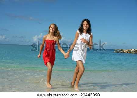 Two sisters (10 and 12) having fun on the beach. Caribbeans.