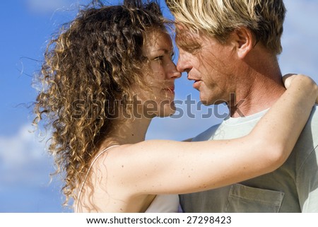 Real people. Real love. Romantic couple on the blue Caribbean sky background.