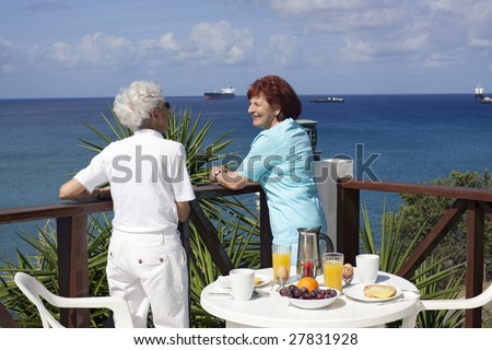 Happy retirement. Two senior ladies enjoying their Caribbean vacation at the hotel terrace.
