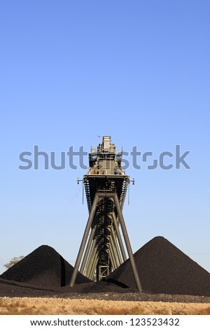 Coal Mining Conveyor Belt and piles of coal with a blue sky background. Australia