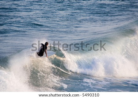 a young male surfer catching a wave