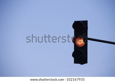 orange traffic light in front of blue sky