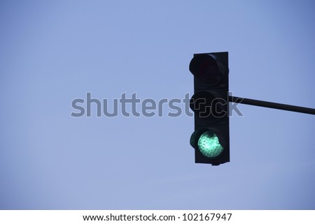 green traffic light in front of blue sky