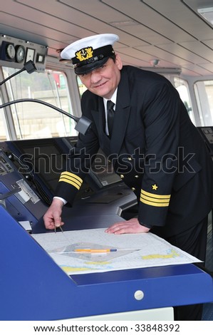 Navigation officer manages devices, looking ahead on the navigation bridge of ocean ship