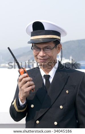 Navigation officer is talking by VHF radio, looking ahead on the navigation bridge of ocean ship