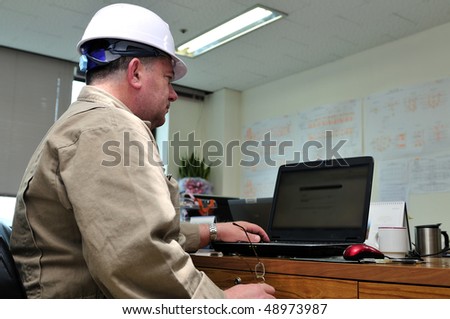 Engineer, working with laptop in office