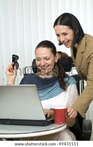 Teamwork: two young lady managers, working in office