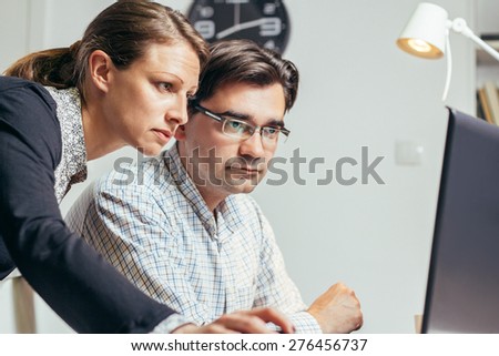 Photo of two young people working late