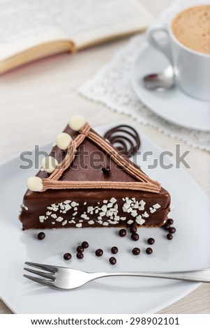 Chocolate Cake with a Coffee cup and a book in the background