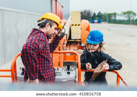 Operator In Safety Helmet and red square shirt receiving instruction for Straight Boom Lift