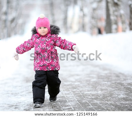 little girl, a child walking in a winter park in snow