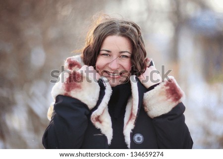 Sunny outdoor winter portrait of young attractive woman. Pretty girl smiling in winter on the street.