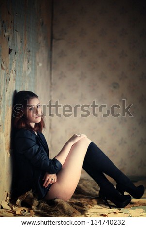stress, nude woman sits and smokes in the old house